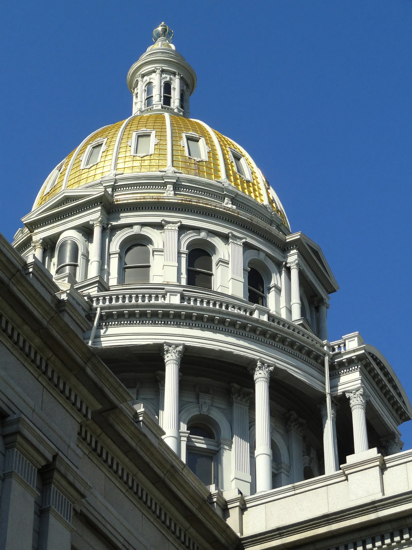 The gold-covered dome of the Colorado State Capitol in Denver rising against the sky, seen from below
